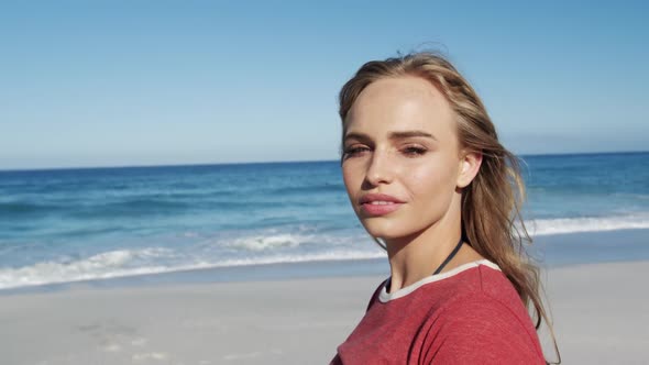 Woman standing on the beach and looking at camera