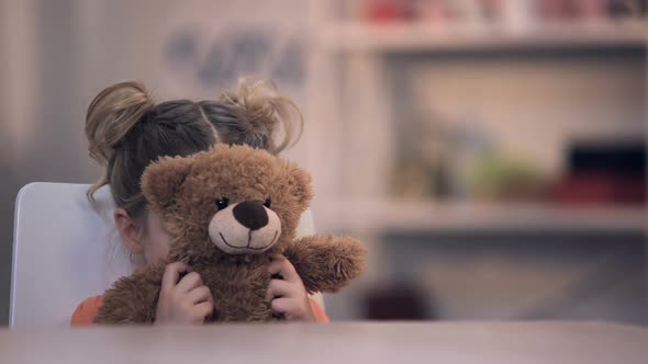 Sad Female Kid Covering Face by Teddy Bear Toy, Family Problem, Loneliness Abuse