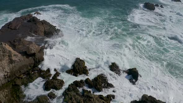 sea waves crashing against the rocks on the beach