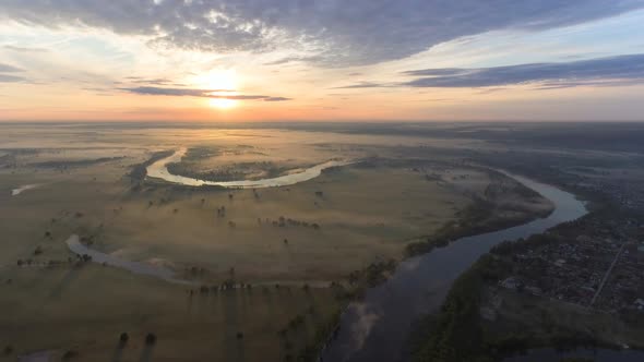 Aerial View of Spectacular Landscape with River Cutting Through the Valley Under Low Sun Beams