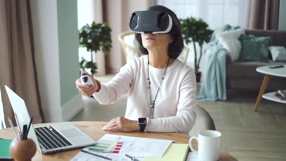 American Old Businesswoman Using Vr Headset Working at Desk with Laptop in Office Room