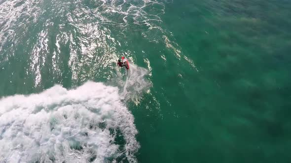 Aerial view of a man sup stand-up paddleboard surfing in Hawaii