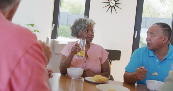 Happy senior diverse people having breakfast at retirement home