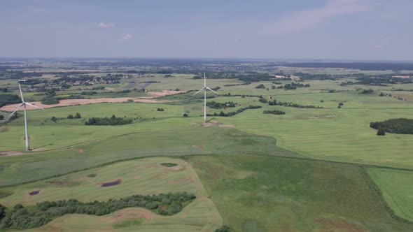 Aerial view of windmills farm for energy production on beautiful cloudy sky at highland. Wind power 