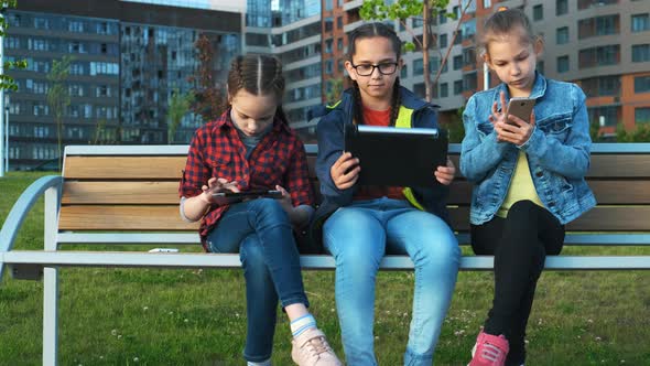 A Group of Children Sitting on a Bench