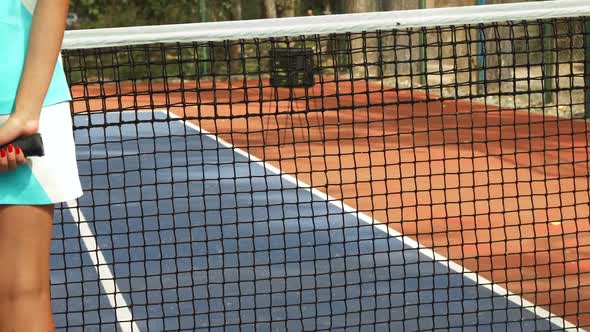 Girl Standing with a Racket Turned Back