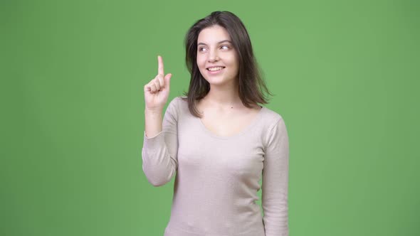 Young Happy Beautiful Woman Thinking While Pointing Finger Up
