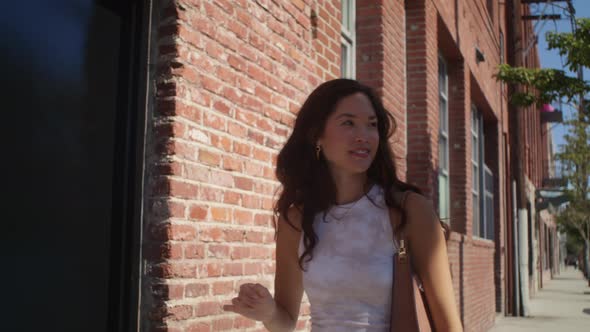 Smiling Girl Walking Near Brick Wall Closeup