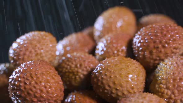 Slow Motion Shot of Fresh Fruits with Splashing Water Isolated on Black Background