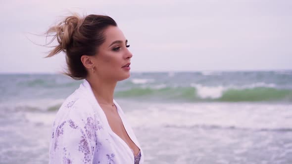 Girl Walks on the Beach on the Background of the Sea