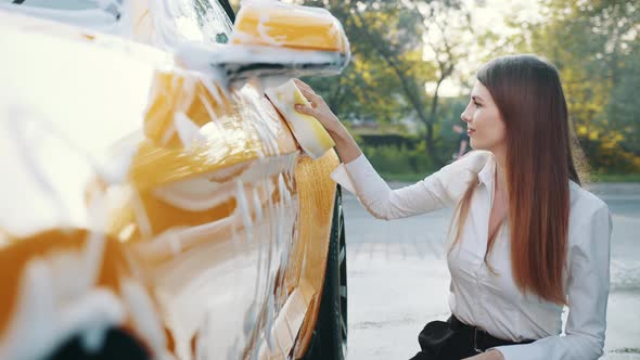 Luxury Yellow Car in Soap Foam Outdoors at Car Wash Service