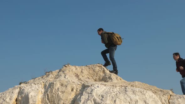 Tourists Go Through To the Top of the Hill Against the Sky. Teamwork of Business People. Three