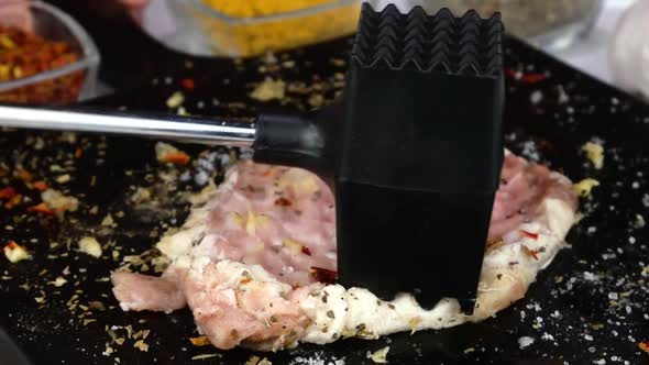 Cook Beats Fresh Raw Pork Fillet with Meat Hammer on Kitchen Board Cooking Chops