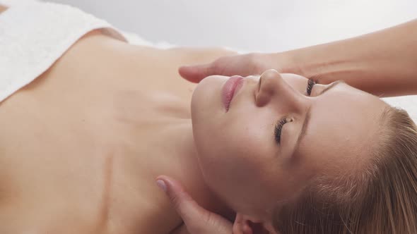 Young, healthy and beautiful woman gets massage therapy in the spa salon.