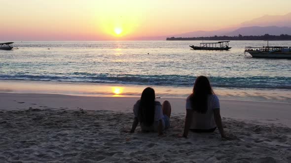 Ladies sunbathing on luxury bay beach holiday by shallow ocean and white sandy background of Gili Ai