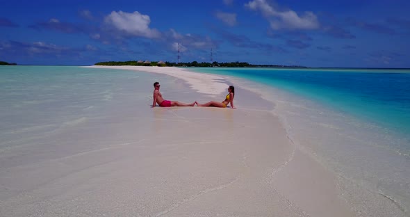 Romantic couple on honeymoon vacation live the dream on beach on paradise white sand background 