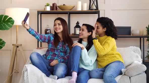 Amiable multiracial girls live streaming from home using smartphone