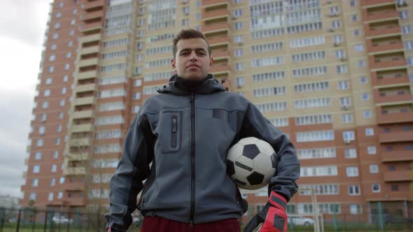 Confident Arab Goalkeeper Posing with Soccer Ball on Outdoor Field