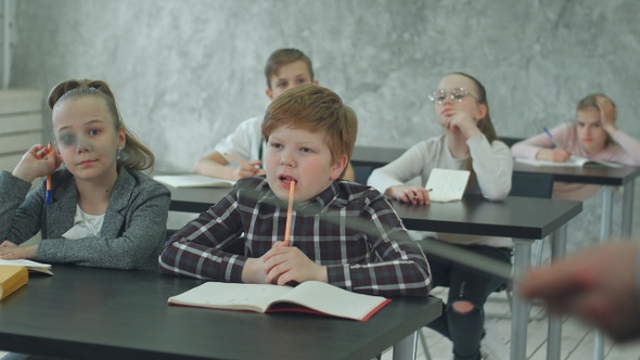 Group of school kids in class together, listening to the teacher