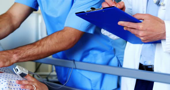 Doctor consulting pregnant woman in ward