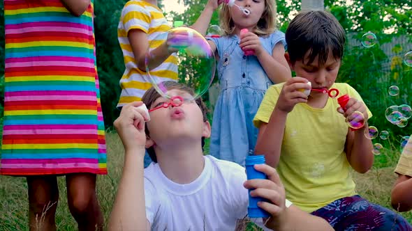 Children Blow Bubbles on the Street