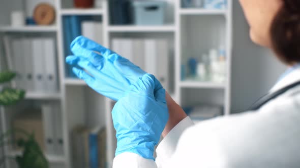 Woman Doctor Puts On Gloves. Sterile Disposable Protective Surgical Gloves. Medical Practitioner