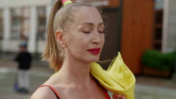 Portrait of a Blonde with a Ponytail on a Blurry City Street