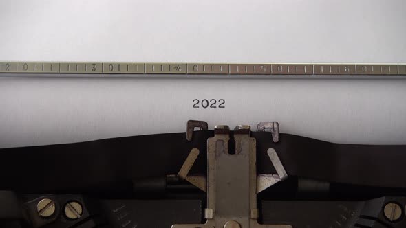 Typing 2022 on retro typewriter. Close up.