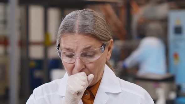 Portrait of Sick Woman Engineer in Protective Glasses and Gloves Coughing at Workplace