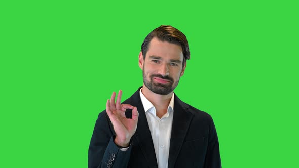 Cool Young Man Doing an Okay Symbol To Camera and Smiling on a Green Screen Chroma Key