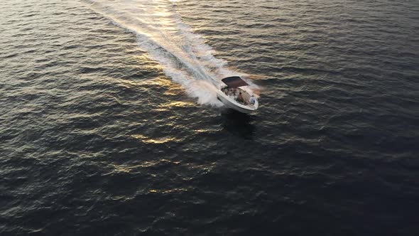 A speedboat speeds across the Adriatic sea near Dubrovnik, Croatia during the golden hour - Aerial