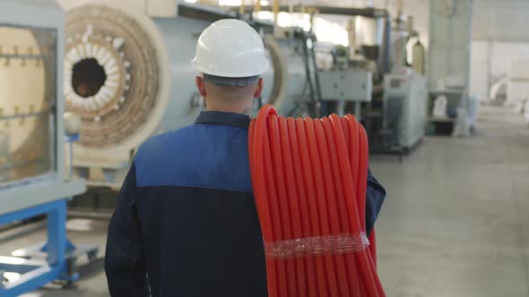  Male Plant Worker in Hard Hat Carrying HDPE Pipes