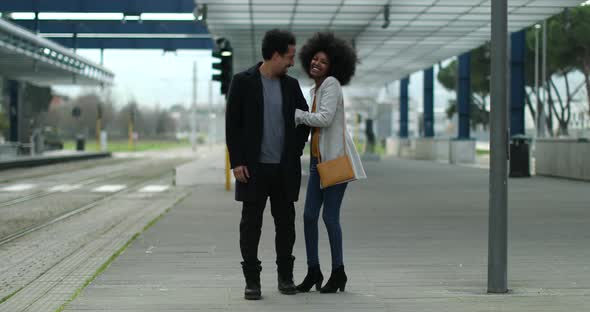 Romantic couple walking arm in arm at train station