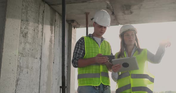 Engineers Designers Stand on the Roof of the Building Under Construction and Discuss the Plan and