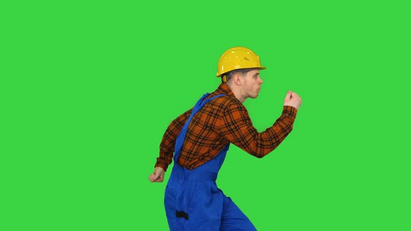 Dancing Young Engineer with Helmet After Work on a Green Screen, Chroma Key.