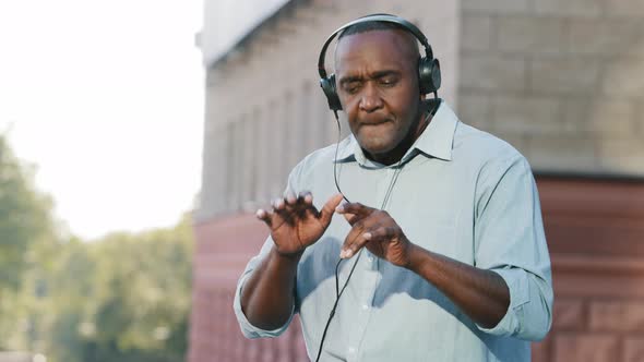 Emotional Senior African American Man Listening Music in Headphones Enjoying Song Audio Player App