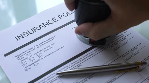 Insurance Policy Document Approved, Hand Stamping Seal on Official Paper Closeup