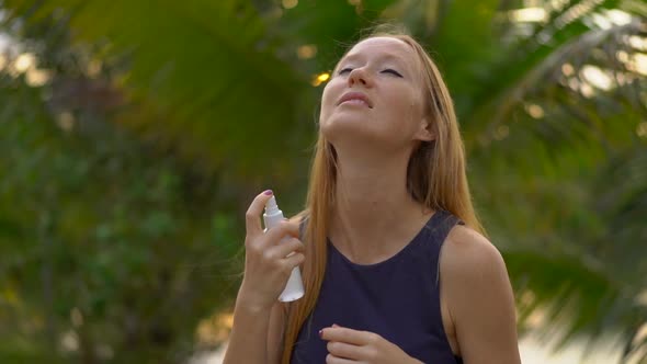 Shot of a Young Woman Applying an Antimosquito Repellent Spray on Her Skin