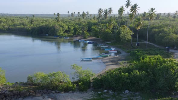 Wooden boats on beach at Soco river mouth, Dominican Republic. Aerial circling