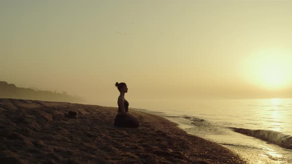 Yoga Woman Practicing Meditation on Sandy Beach