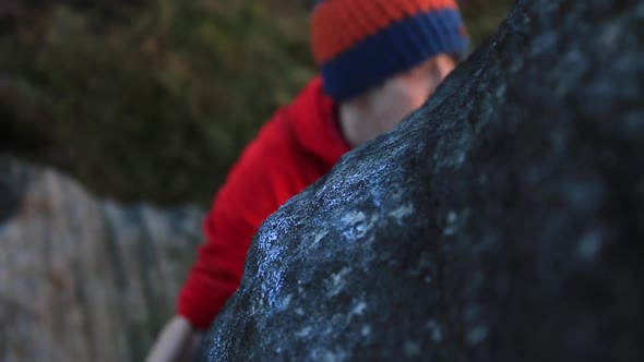 Detail of a young mans hand while he climbs boulders while bouldering.
