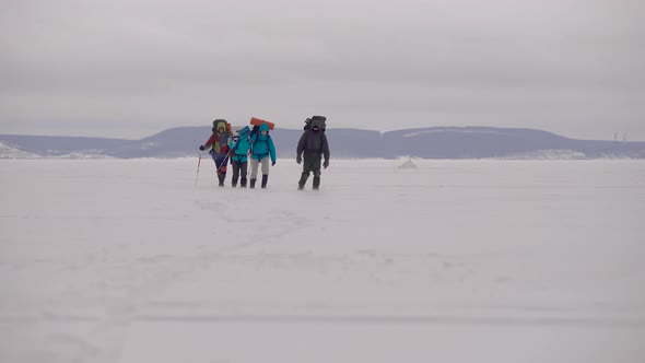 Four Young People Go Hiking in the Snowy Desert