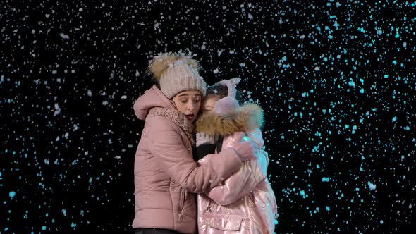 Mom and Child Froze and Hug To Keep Warm. A Woman and a Little Girl in Warm Winter Clothes on the