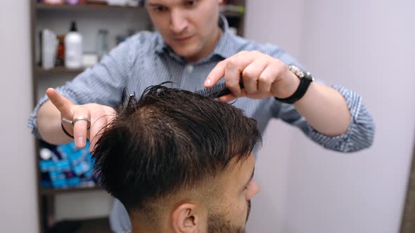 An Energetic Young Man Wants To Change His Hair Style. The Miller Dries Her Hair with the Hair Dryer