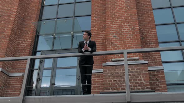 Businessman in Suit Standing Outside Loft Office