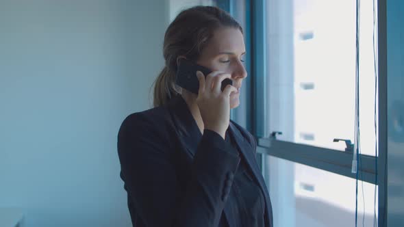 Serious Pensive Young Businesswoman Standing Near Window