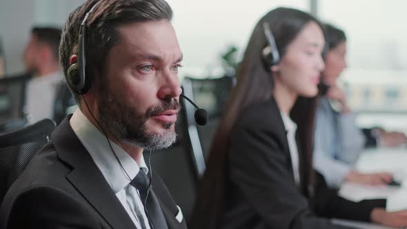 Close Up Portrait of a Technical Customer Support Specialist Talking on a Headset While Working on a