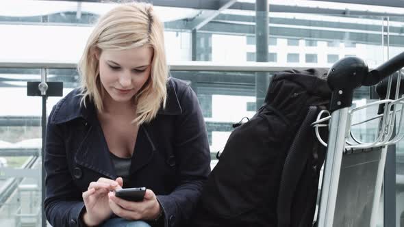 Young Adult Female on smart phone and waiting in airport