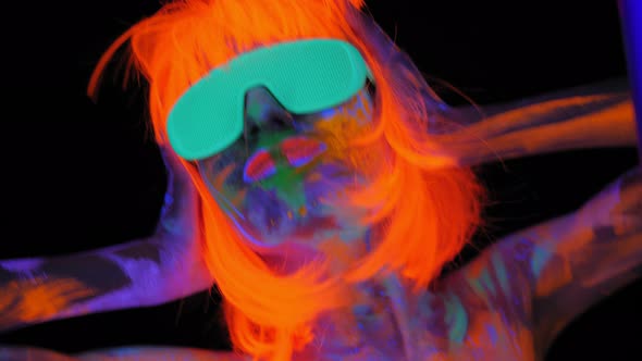 A Girl with an UV Pattern on Her Face Wearing an Orange Wig and Green Glasses