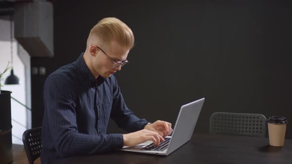 Young Man Working On Laptop In Office